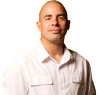A man in white shirt and black pants standing next to a door.