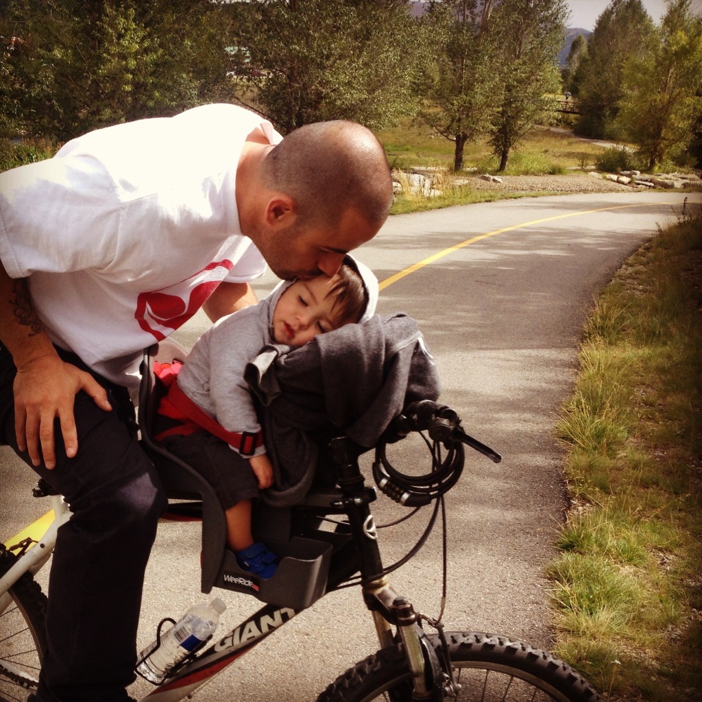 A man and child on a bicycle.